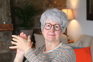 Senior woman clapping at home