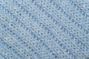 Blue knitted wool fabric background. Very warm natural knitwear. Handmade activity.  
