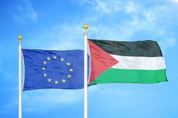 European Union and Palestine two flags on flagpoles and blue cloudy sky