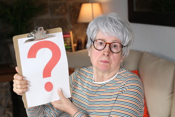 Senior lady holding question mark