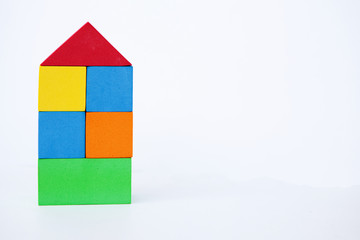 Toy house on a white background. A house made of colored cubes. With space for writing