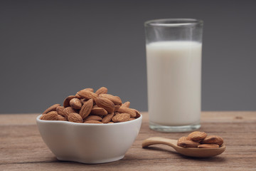 Almonds in white porcelain bowl on wooden table