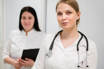 Female doctor and nurse with stethoscope indoors