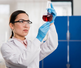 Side view of female scientist looking at lab substance