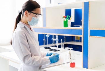 Side view of female scientist with medical mask in the lab
