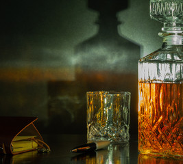 notepad with pen, bottle and glasses of whiskey with ice on black background