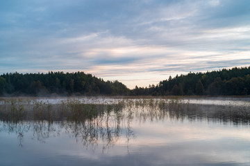 Sunset over wetlands at Skekarsbo, Sweden, with golden light reflecting on still water and reeds