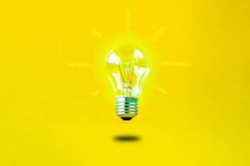 levitating burning bulb on a yellow background