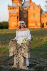 blonde girl in a white dress on nature near architectural monuments in the open air