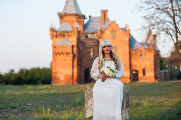 Obraz premium blonde girl in a white dress on nature near architectural monuments in the open air