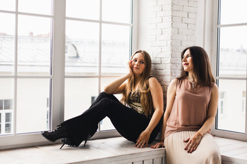 Girls, sisters sitting at home on the window, communication with a friend, laughter and fun, henna...