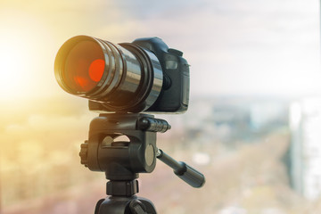 Digital camera is on the tripod with telescope lens on. Red lens filter set on.