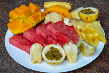 Fototapeta na wymiar Tropical fruits on a breakfast plate, close up, top view