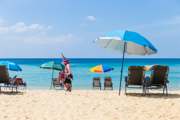 Obraz na płótnie Canvas Summer beach, relaxing by the sea, beautiful blue sea and clear blue sky, chair on the sandy beach under a colorful umbrella