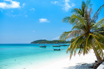 Fototapeta na wymiar Beautiful tropical beach and ocean with boat and beautiful clear blue sky background
