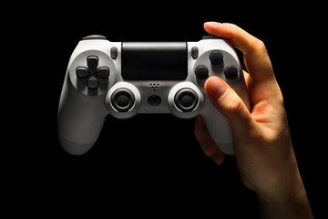 Hyman hand holding white video game gamepad isolated on a black background