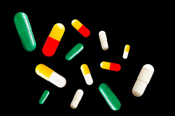 Medical pills fly on a black background. Levitation.