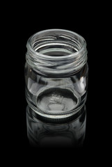 Empty open glass jar with reflection. Isolated on a black background