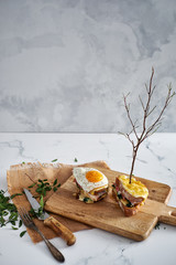 Grilled cheese sandwich with fried egg on a wooden board