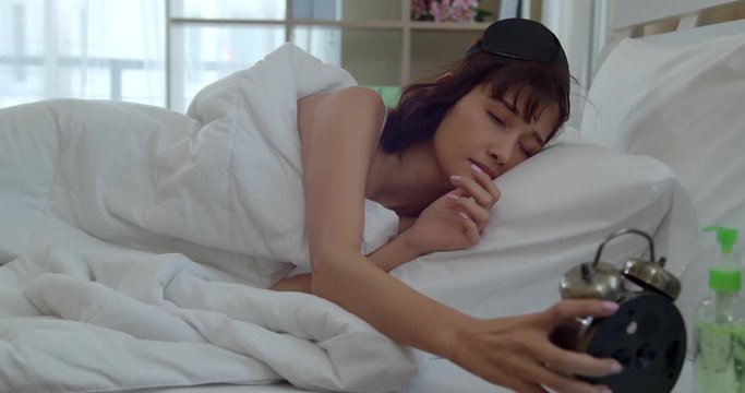 Asian young woman wake up late with alarm clock