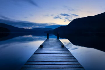 Foto op Plexiglas Wooden Jetty/Pier Leading Out To Calm Lake With Reflections At Blue Hour In The Lake District, UK. © _Danoz