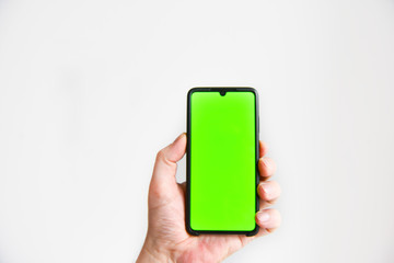 a hand with a smartphone with a green background