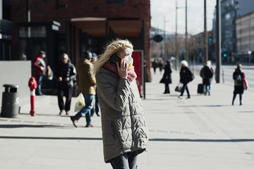 COVID-19 Pandemic Coronavirus Young girl in city street wearing face mask protective for spreading of Coronavirus Disease 2019. Close up of young woman with surgical mask on face against