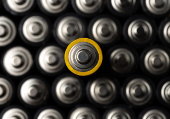 Energy abstract background of batteries. Close up top view on rows of selection of AA batteries....