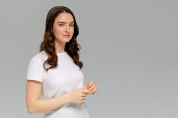 Thoughtful attractive young woman thinking and looking away over gray background