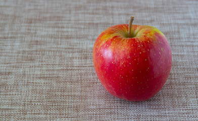 red apple on gray linen cloth.copyspace for text