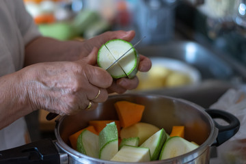 Grandmother's hands cutting zucchini