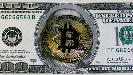 golden bitcoin coin on us dollars close up