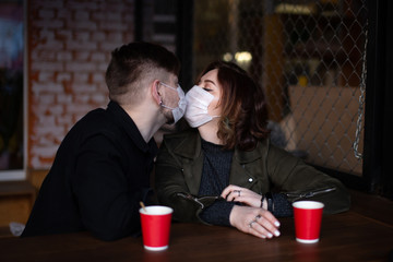 Young beautiful couple of boyfriend and girl lovers sit in a cafe in honey masks and kiss.