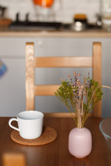white mug against the kitchen background on the table with a blurred background. composition kitchen