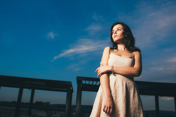 Portrait of pretty woman on the evening sky background. Copy space