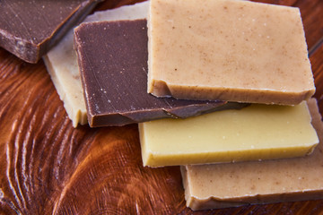 Handmade soap bars on wooden board. Mock up eco paper packaging for soap. Craft natural soap on wooden table