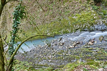 mountain river with a small bridge in the spring in the gorge