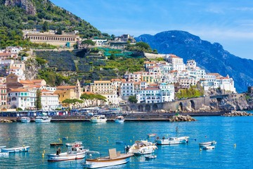 Fototapeta premium Beautiful Amalfi with hotels on hills leading down to coast, comfortable beaches and azure sea in Campania, Italy.