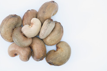 Cashew nuts with shell waiting to be processed on white background