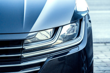 Led headlight of a gray modern car. Modern trends in the automotive industry. Head optics of the...