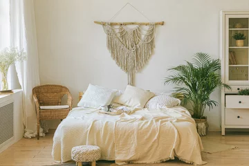 Fototapete Boho Modern scandi boho style bedroom interior with decorative pillows, green plant and diy macrame wall panel. Light warm cozy comfortable home. jomo, weekend breakfast in bed. Slow living concept.  © Aleksandra Konoplya