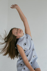 vertical portrait on gray background teenage girl dancing with closed eyes