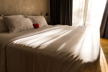 Loft Style Bedroom Interior Design with Red heart and white pillow on the bed for love, wedding and valentine's day concept