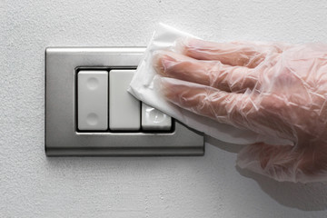 hand in glove disinfecting light switch 