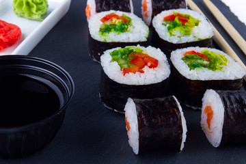 Colorful vegetarian sushi set on a black plate