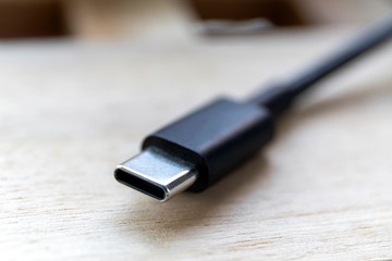 A close up portrait of a male universal serial bus connector of type C or abbreviated USB-C. It is used to connect or charge multimedia devices.