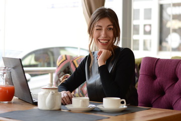 business woman wink smiling sitting at table in cafe