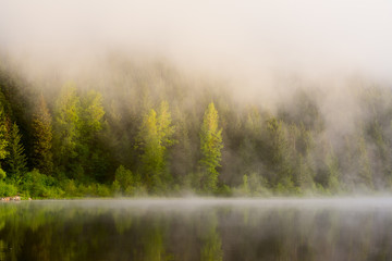 Naklejka na ściany i meble Early Morning Fog Rising Over Lake