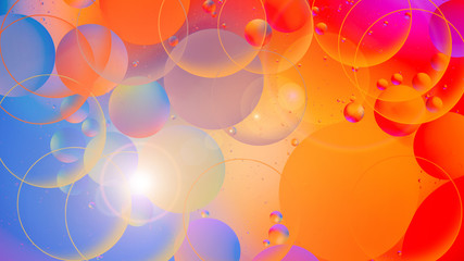 bright oily drops in water with colorful background, close-up 