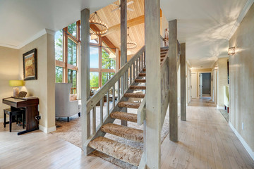 Large open staircase with great huge living room and piano in the side. Beautiful large chalet home.